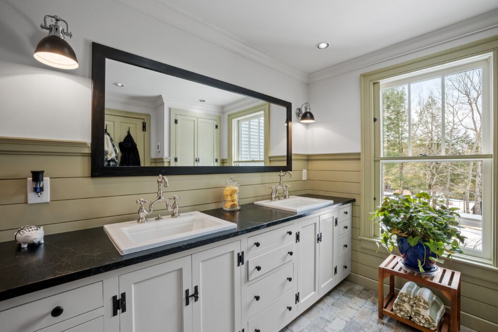 A minimalist style furnished bathroom with a horizontal long mirror with lamps and white cabinets