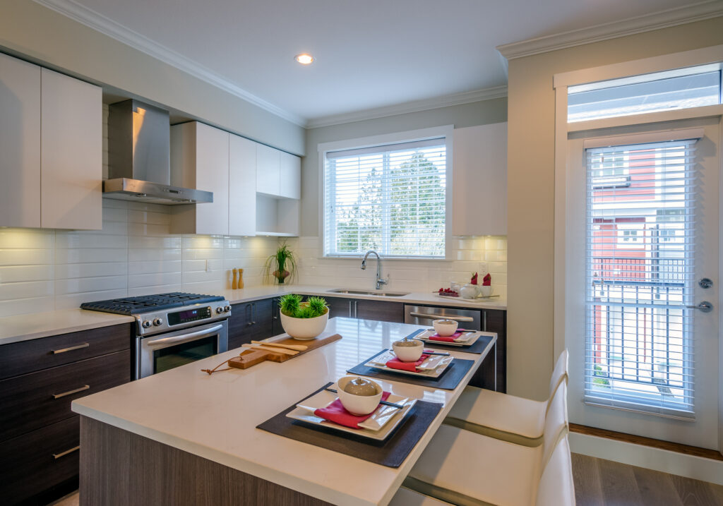 Contemporary kitchen with beige cabinets, large windows, and a spacious island