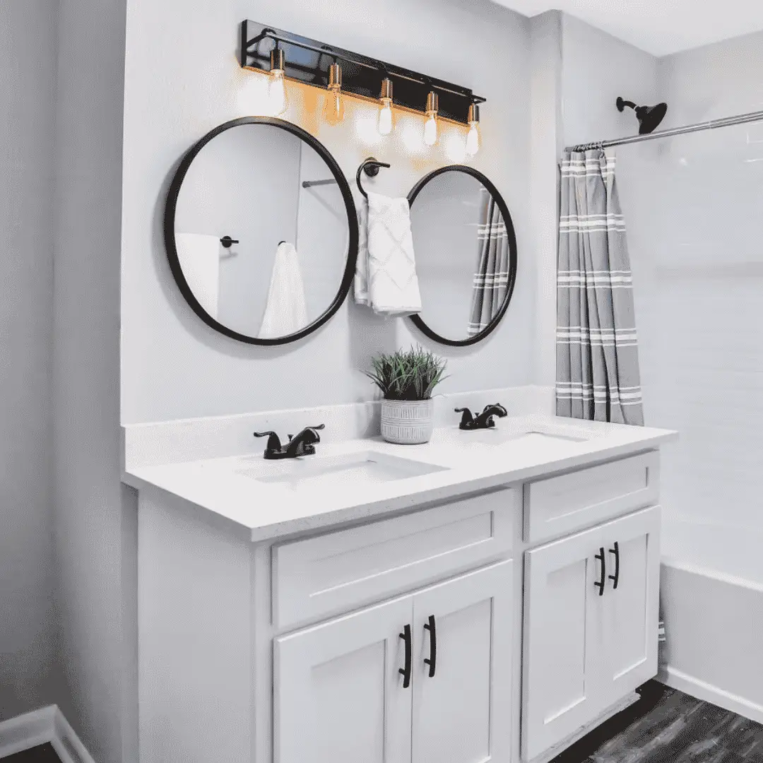 white bathroom cabinet with double vanity and circular mirrors